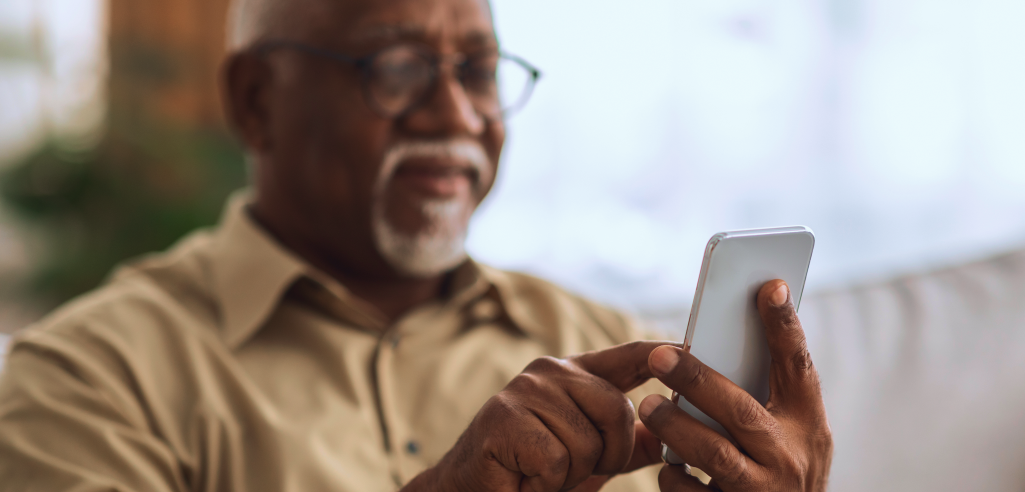 Imagem ilustrativa de um homem idoso utilizando um smarthphone e tendo uma boa experiência em UX writting