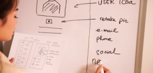 Imagem ilustrativa de uma mulher desenhando insights da etapa de UX Research em um quadro branco